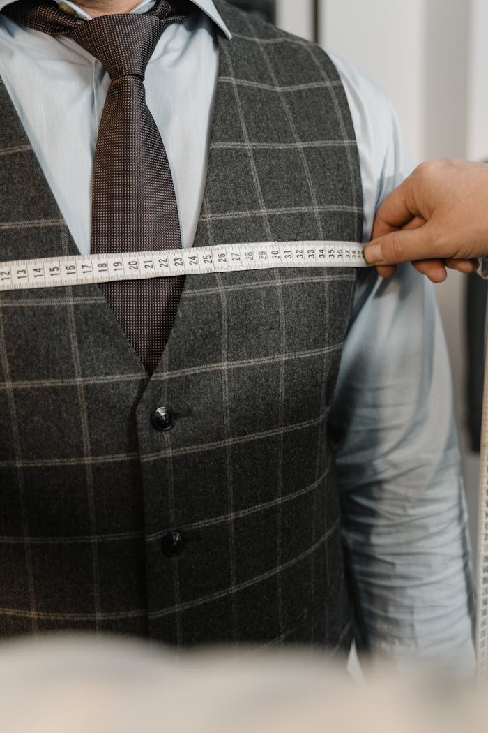 services-03 Tailor measuring client's chest for a tailored suit in an atelier setting.